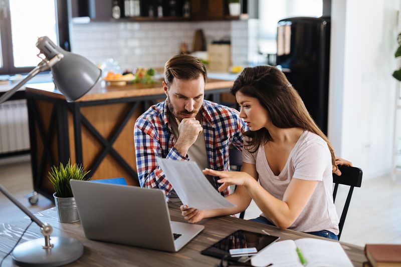Couple Checking Bills at Home Using Laptop