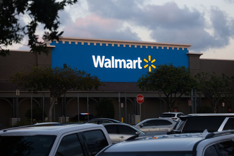 Cars are parked in a Walmart parking lot. 