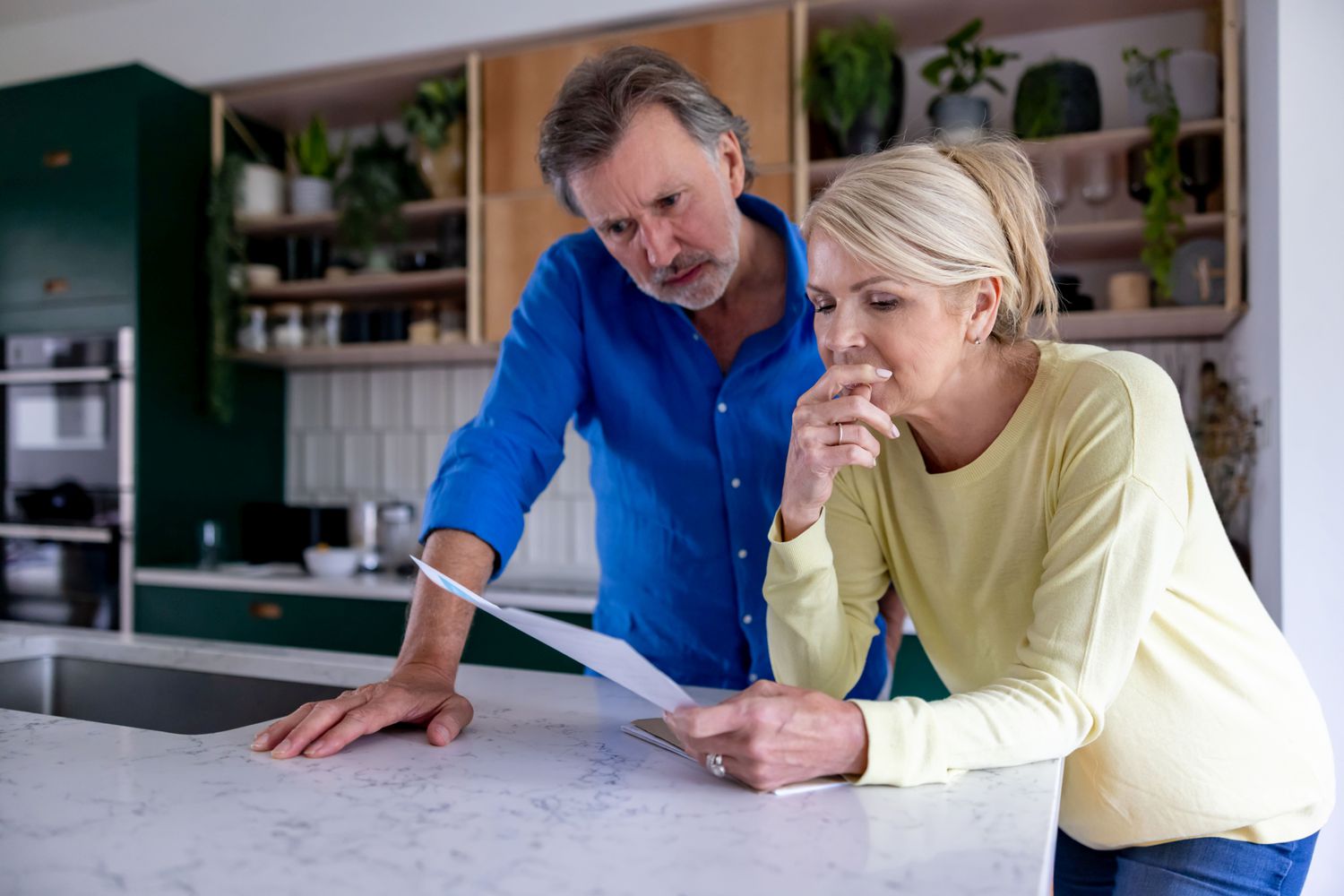 Couple reading a letter in their kitchen