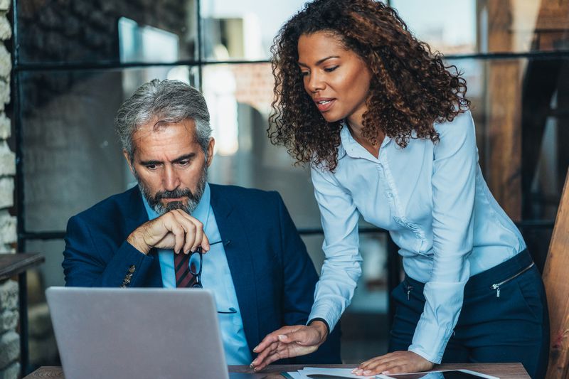 business man and business woman looking at a laptop in an office