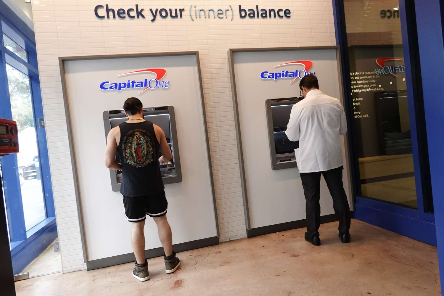 Customers make a transaction at a Capital One ATM on February 19, 2024, in Miami, Florida. 
