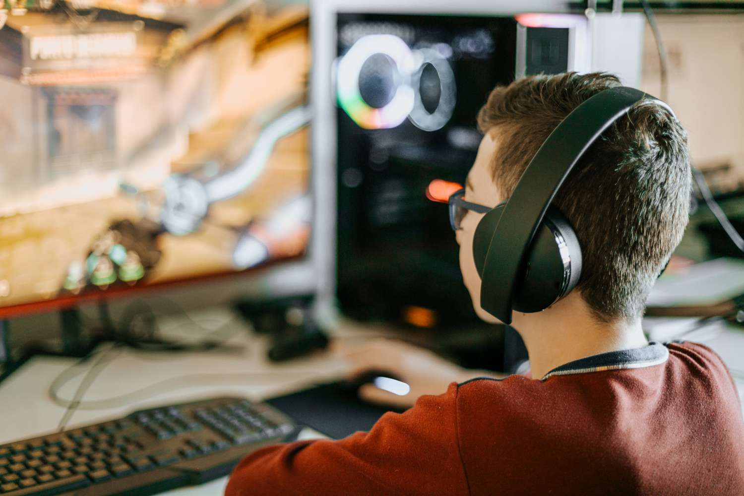 A child playing computer games and wearing a headset