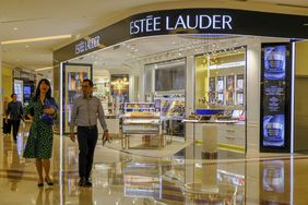 A couple walks by Estee Lauder store in Kuala Lumpur