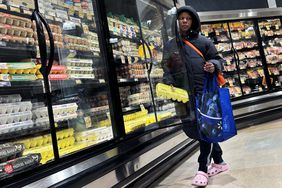 A shopper takes a carton of eggs from the cooler in a grocery store in Washington, D.C., on Saturday, April 6, 2024. 