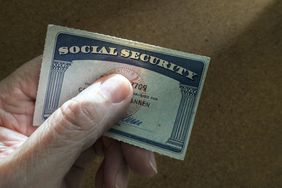 A hand holding a Social Security card