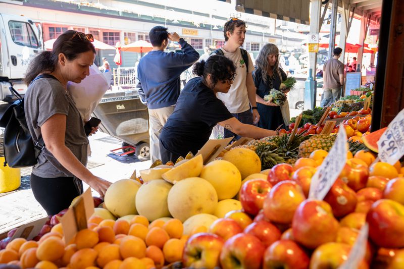Shoppers look at fruit for sale at Frank's Quality Produce Co. at Pike Place Market in Seattle, Washington
