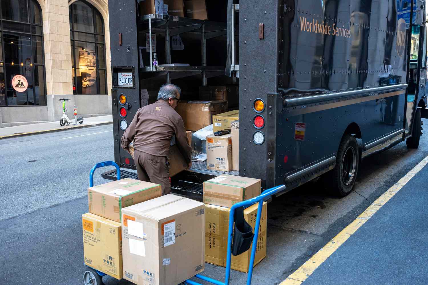 A driver unloads packages from a UPS truck