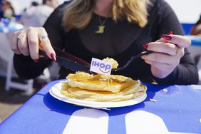 A woman prepares to eat pancakes. 