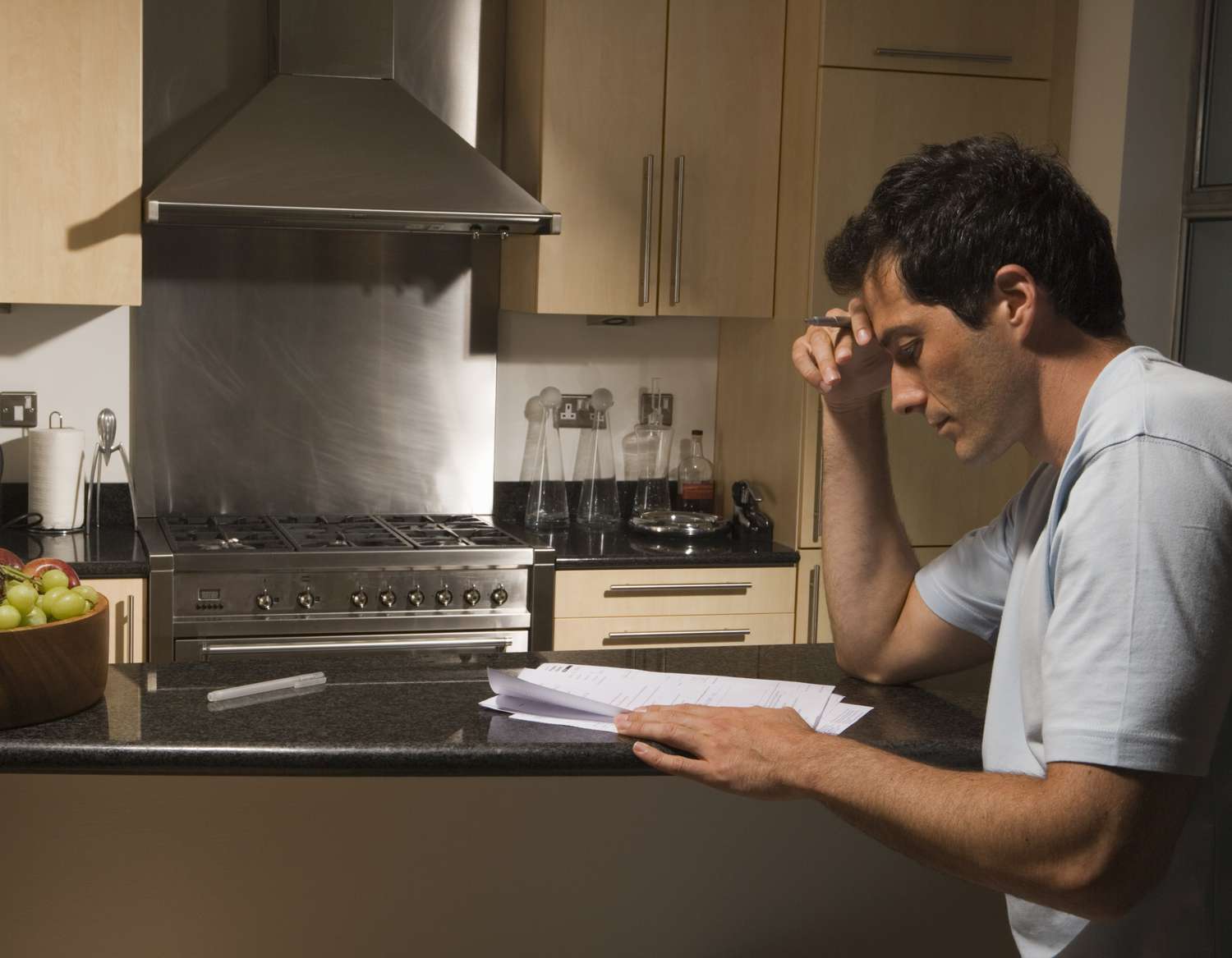 Man reading paperwork in kitchen