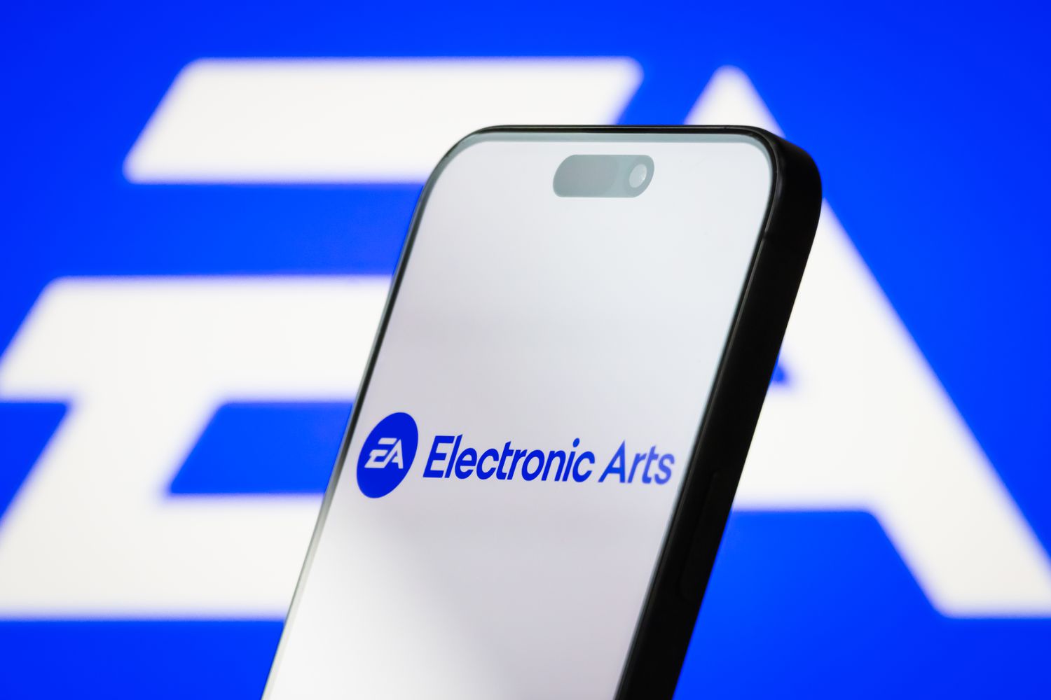 the logo of Electronic Arts Inc. is displayed on a smartphone screen, with the company's iconic EA branding visible in the background