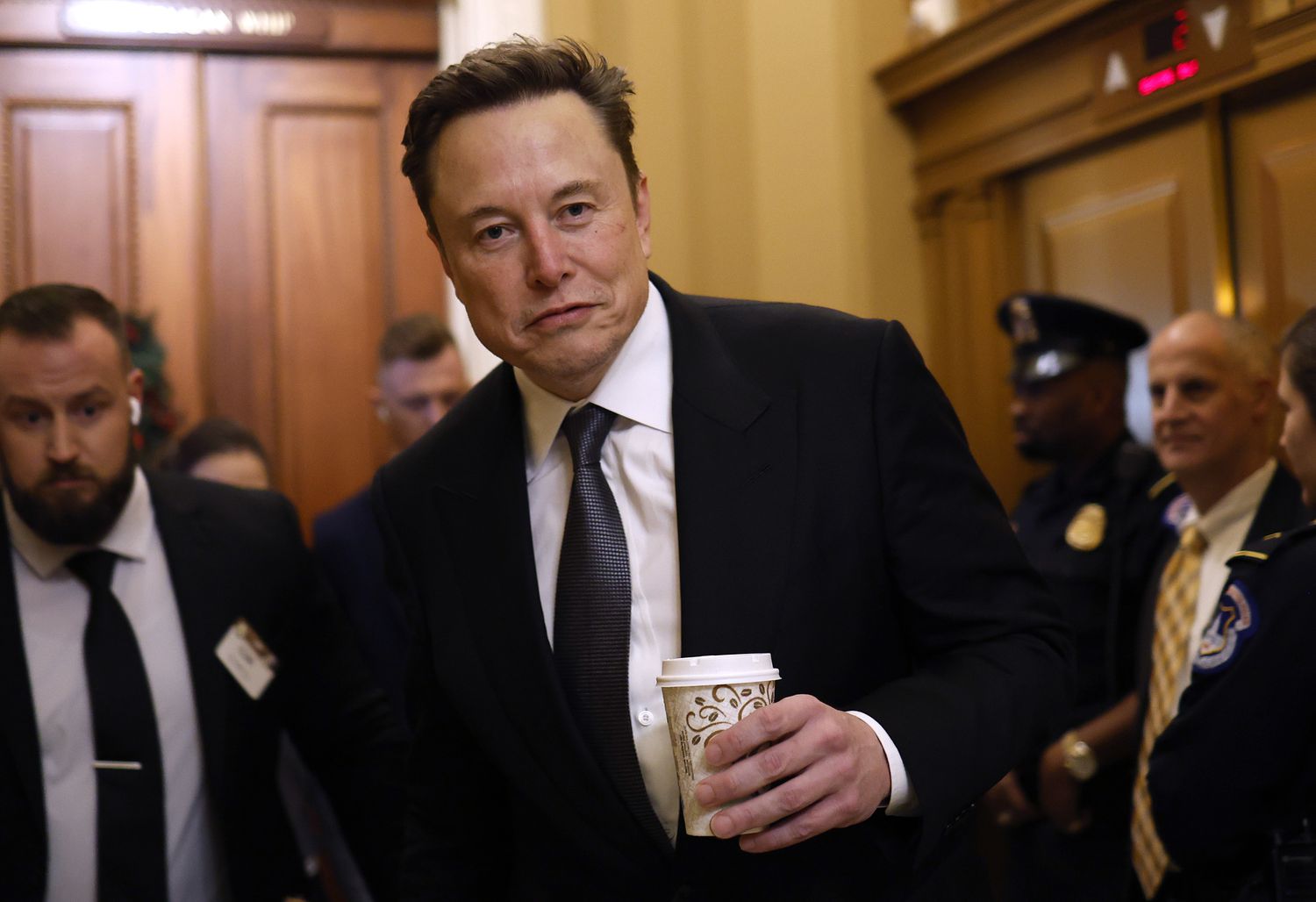 Elon Musk and other people are seen walking through the Capitol building in Washington, D.C.