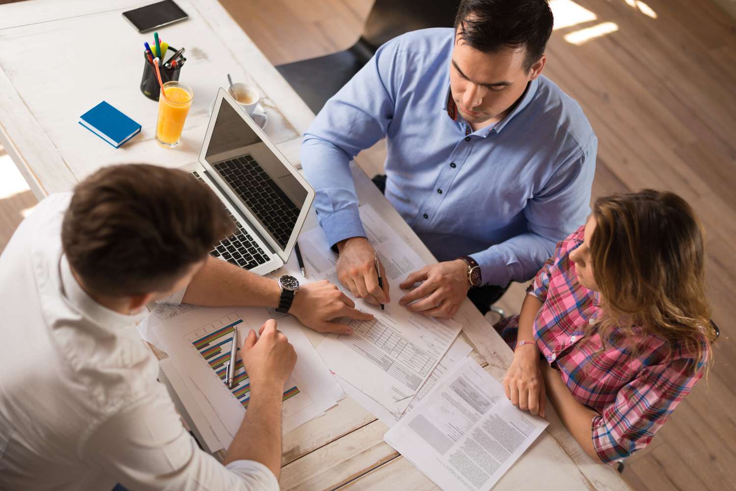 Young couple signing a contract on a meeting with investment agent in the office.