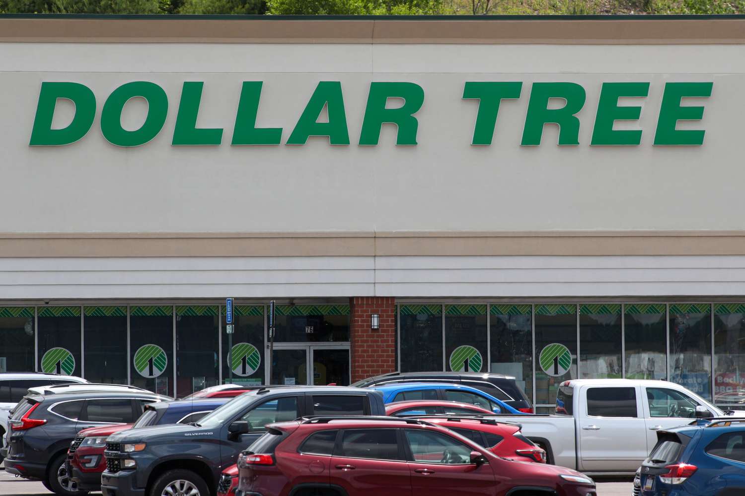 Cars and trucks are seen in front of a Dollar Tree store.