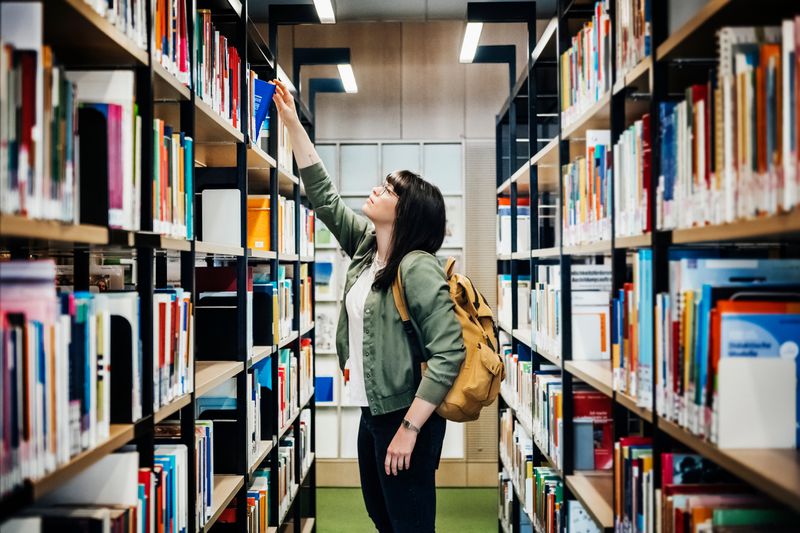 A student browses books in a library.