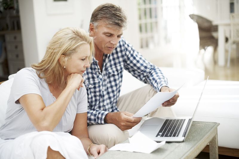 Man and woman looking confused over paperwork