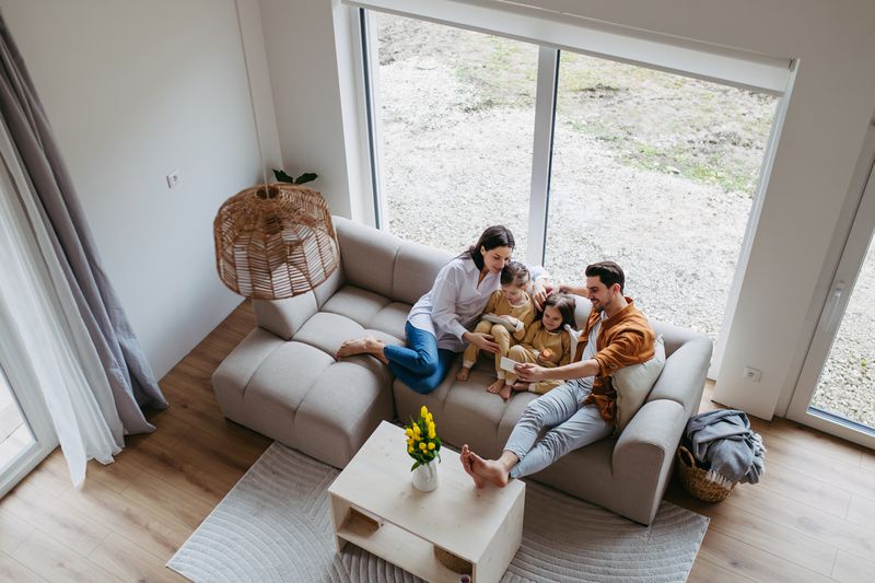 Aerial view of a family of four with two young kids sitting on a sofa.
