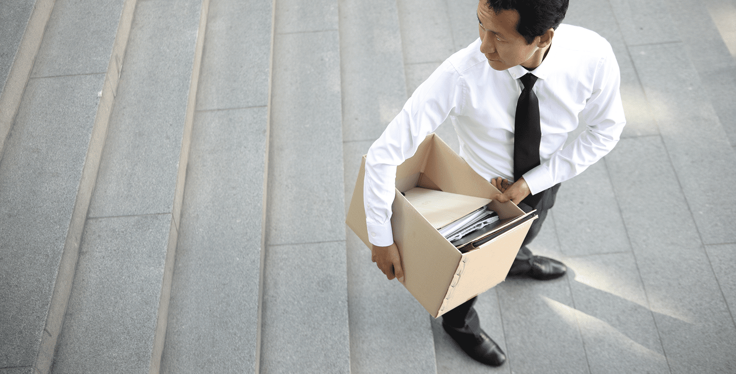 A man with his office supplies in a box