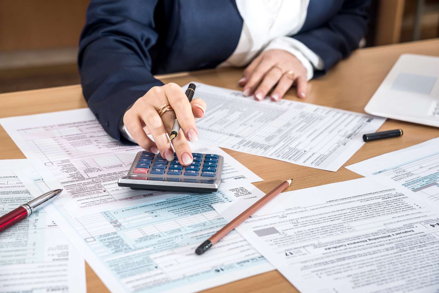 A taxpayer uses a calculator as they calculate their total short-term capital gains for filing taxes.