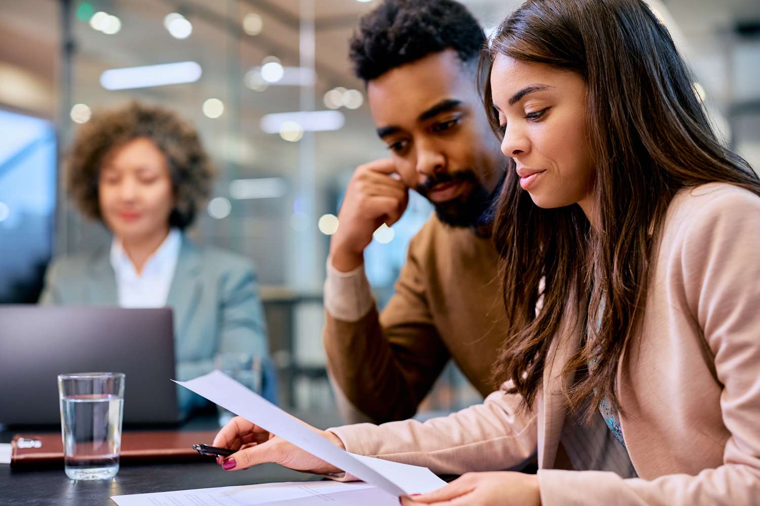African American couple going through their financial reports during a meeting with an insurance agent.