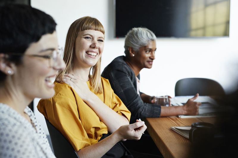 Co-workers discuss their 401(k) program at work during an HR meeting.