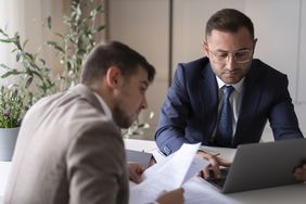 Mortgagees reviewing mortgage applications for approval.