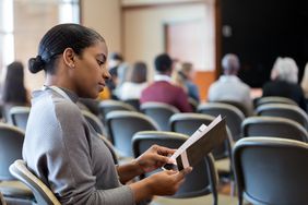 Woman reads a college pamphlet about how to get the maximum student financial aid