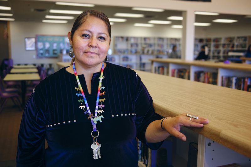 A portrait of a Native American Navajo high school teacher in a school library