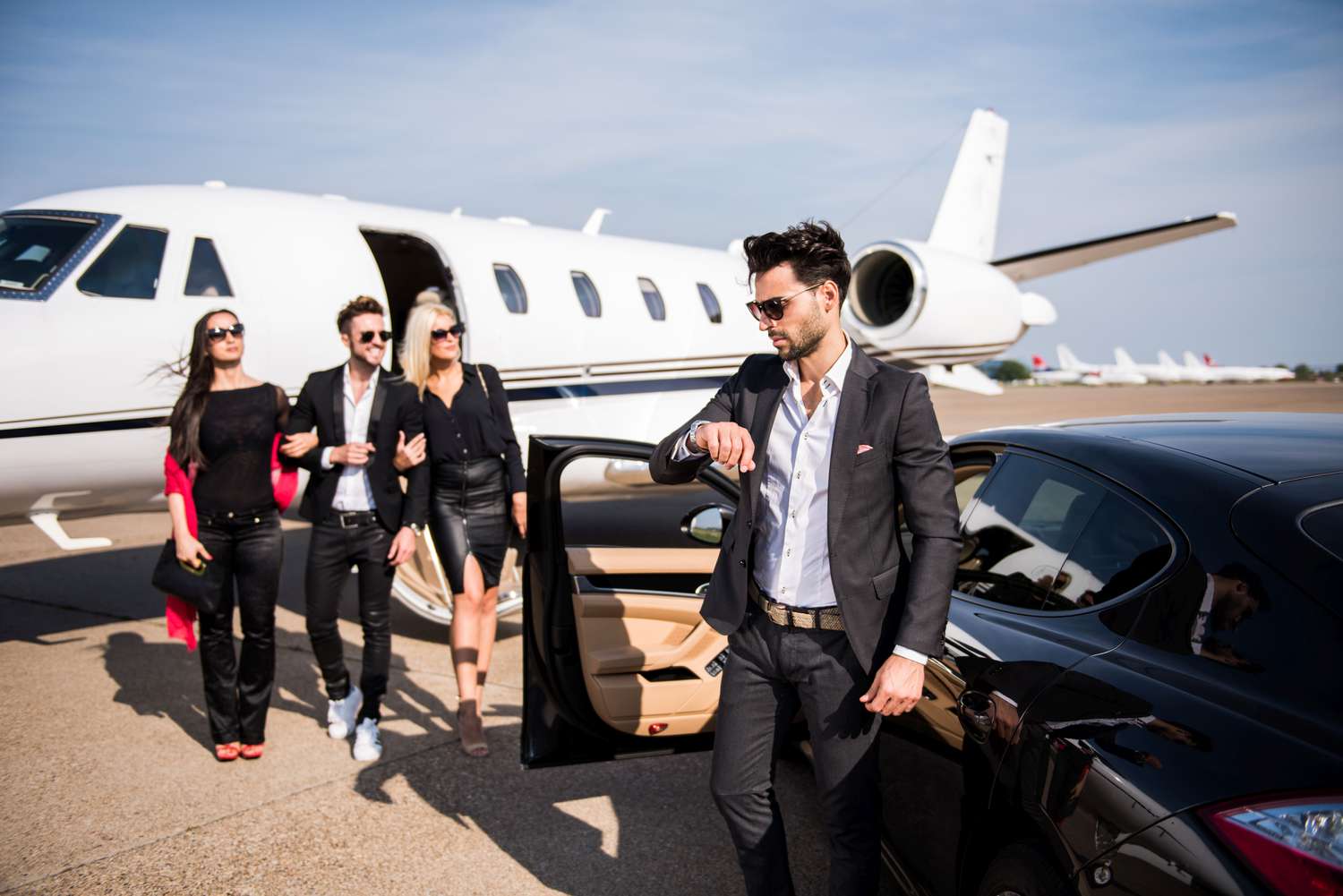 People getting off a private jet and walking to a black car on the tarmac