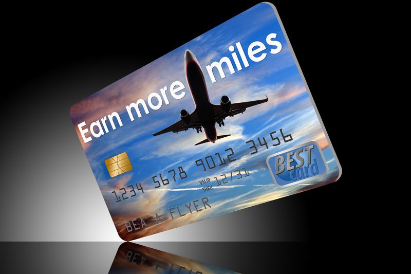 Earn more airline miles credit card on reflective dark background.