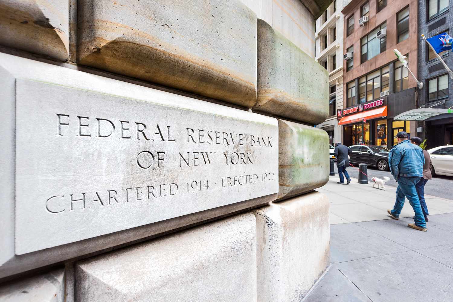 People walking outside the Federal Reserve Bank of New York