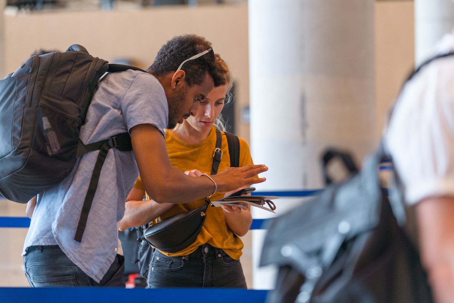 A couple at an airport terminal checking their flight information and tickets 