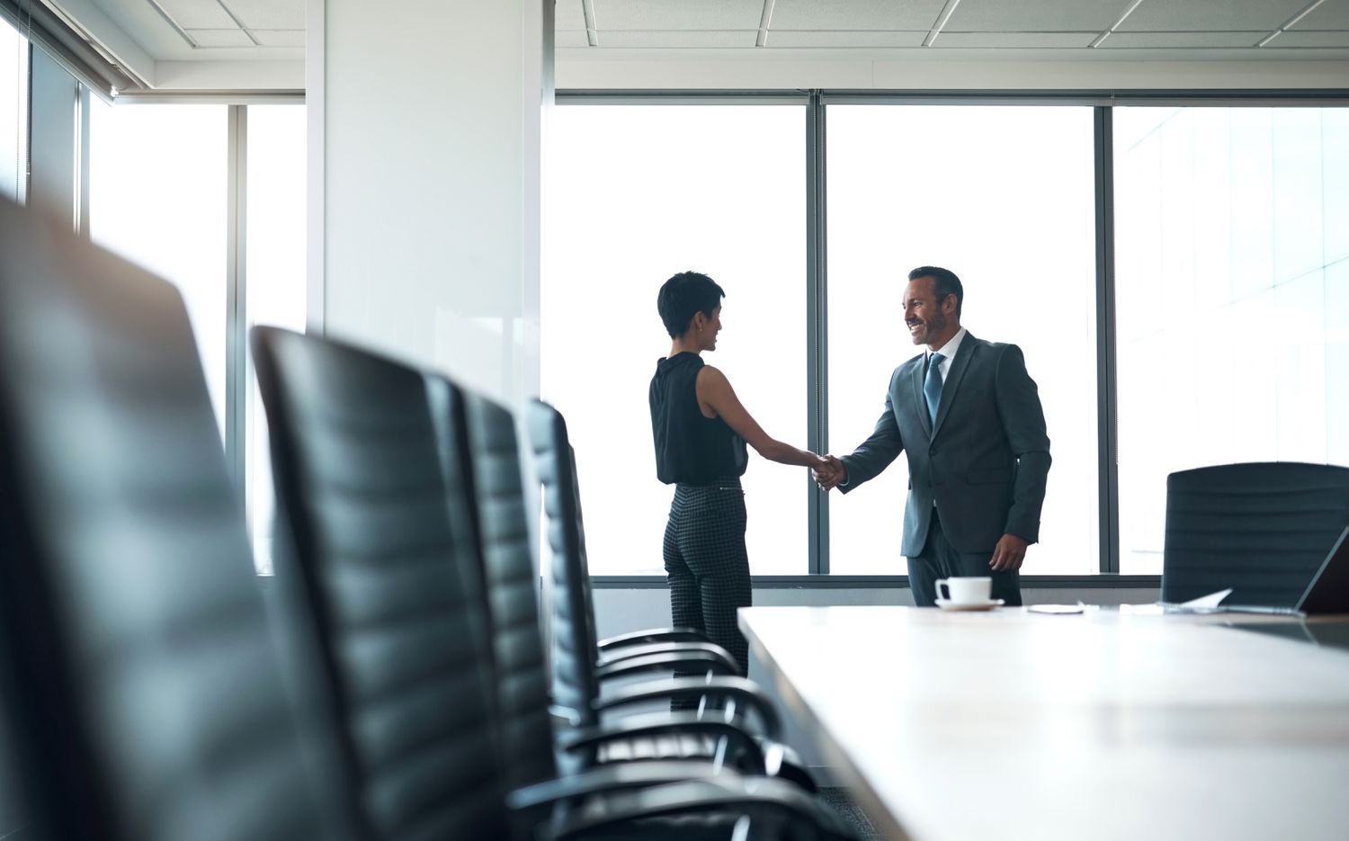A startup business owner shakes hands with a venture capitalist after receiving an agreement for financing.