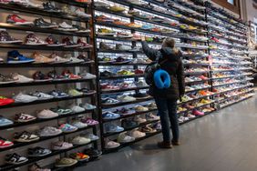 A shopper looks at shoes in a store. 
