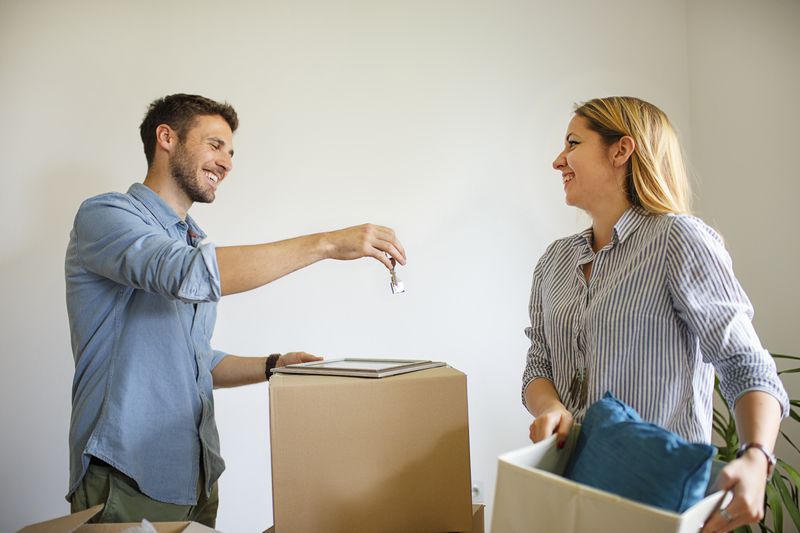 Landlord gives new tenant the house key during moving in.