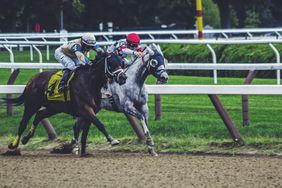 Two jockeys vie for the advantage in a horse race.
