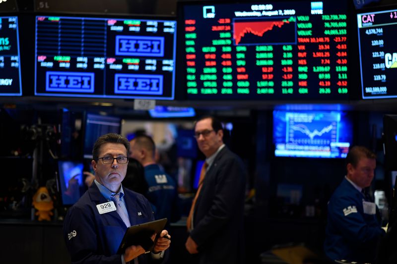 Traders work beneath screens with financial data at the New York Stock Exchange