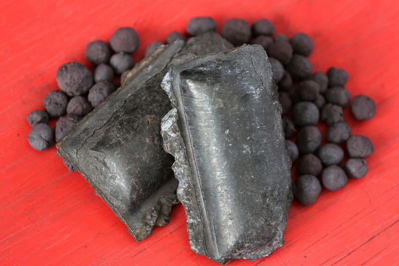 Hot briquetted iron (HBI) and iron ore pellets stand on display.