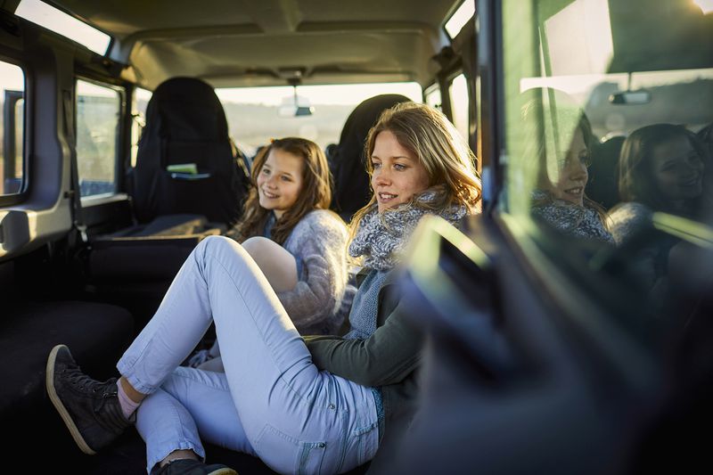 Smiling Mother and Daughter Sitting in an Off-Road Vehicle