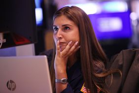 Woman sitting at desk in front of laptop staring ahead