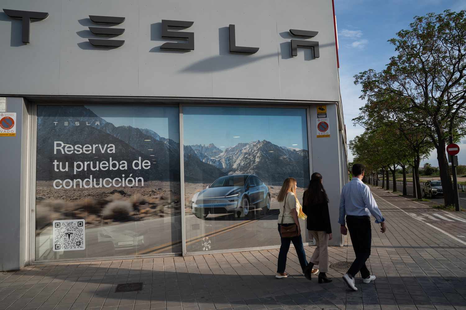 This photo shows people walking by a Tesla dealership in Spain.