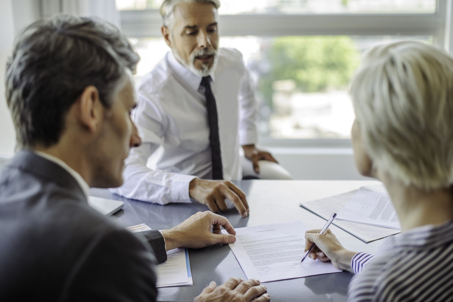 An insurance agent explaing the surrender fee for insurance policy with a couple before they sign the documents.