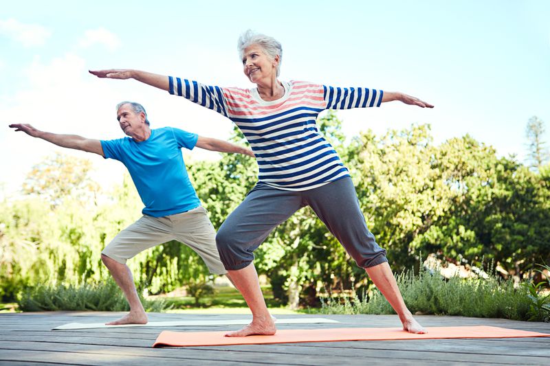 Senior couple doing yoga outside