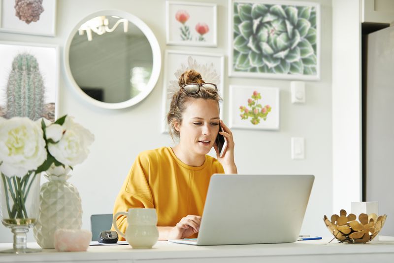 A person talking on the phone to request for annual credit report while sitting at home office.