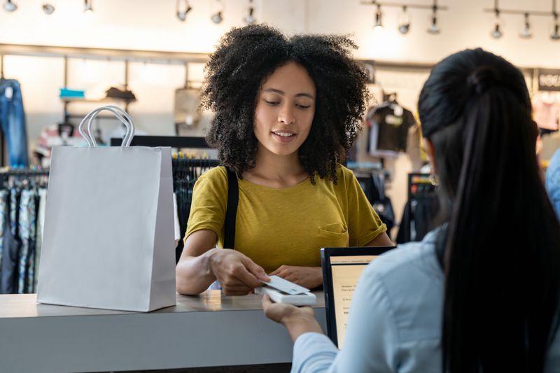 A customer paying for clothes shopping at the store using Sears credit card for rewards.