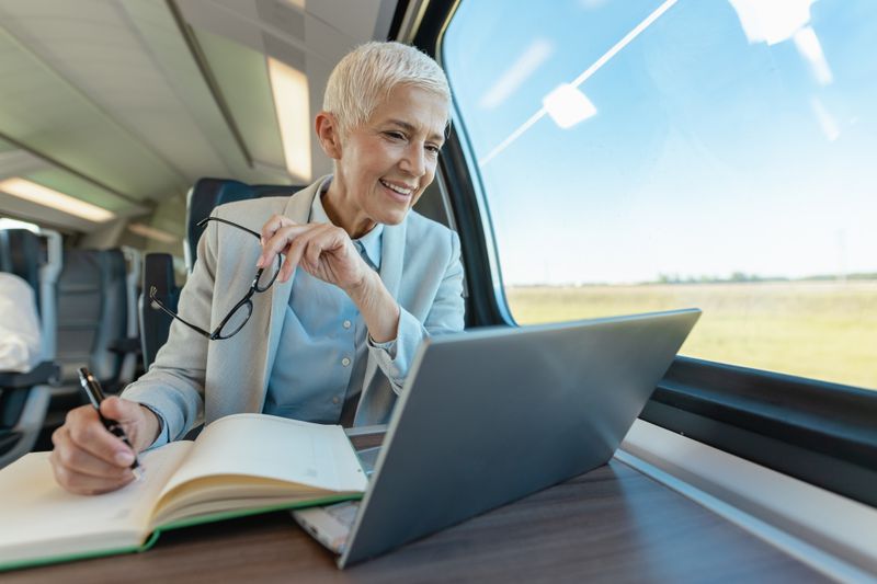 Businessperson with a notebook and computer on a train