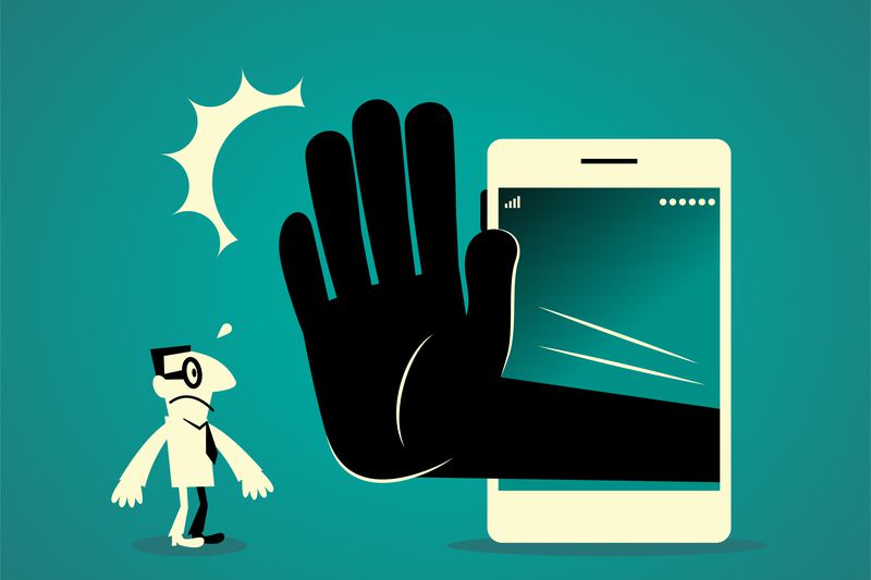 Businessman standing in front of a big smart phone (mobile phone) with a big hand making stop gesture (No!).