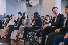 Asian seminar participants in businesswear breaking ice before the business conference start