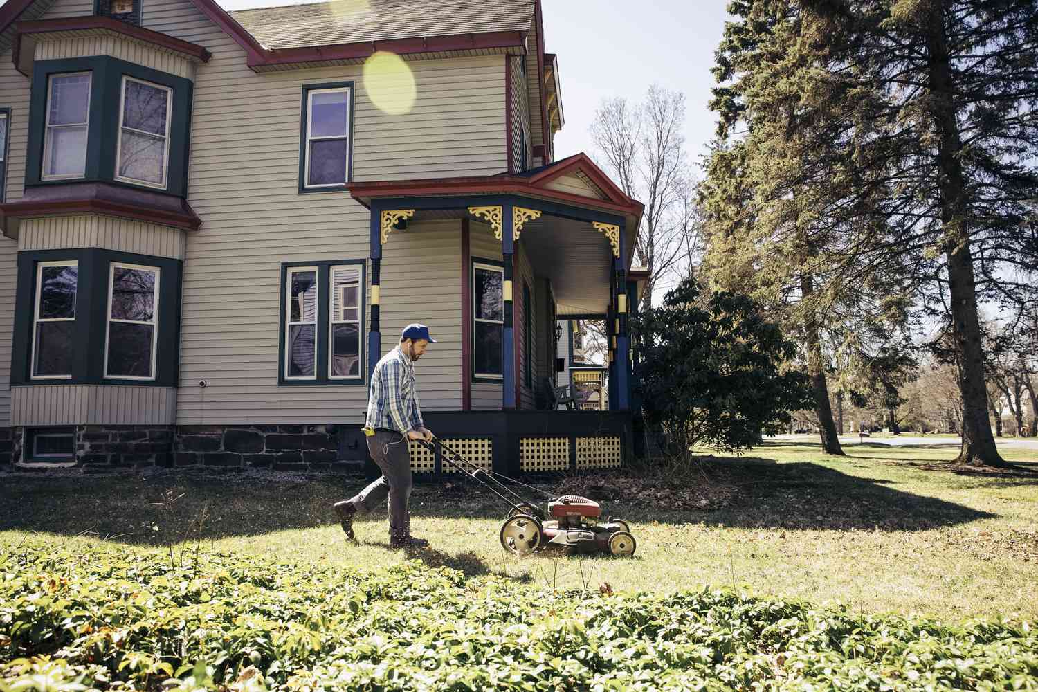 Man mowing grass on sunny day