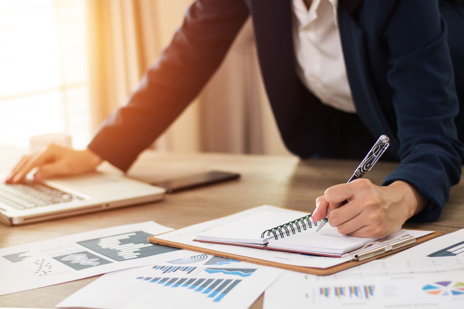 Hands of financial manager taking notes