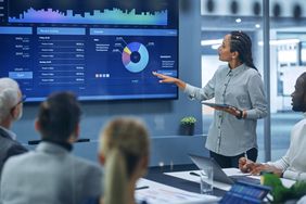 Business woman pointing to graph in meeting room